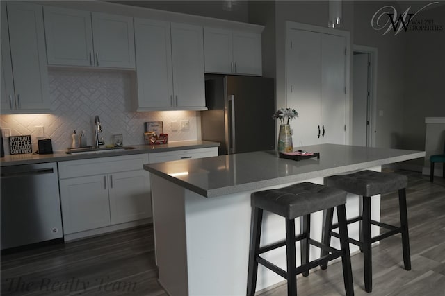 5902 Gardendale Dr Unit C, Houston, TX 77092 - kitchen with stainless steel appliances, dark wood-type flooring, decorative backsplash, a kitchen bar, and a kitchen island