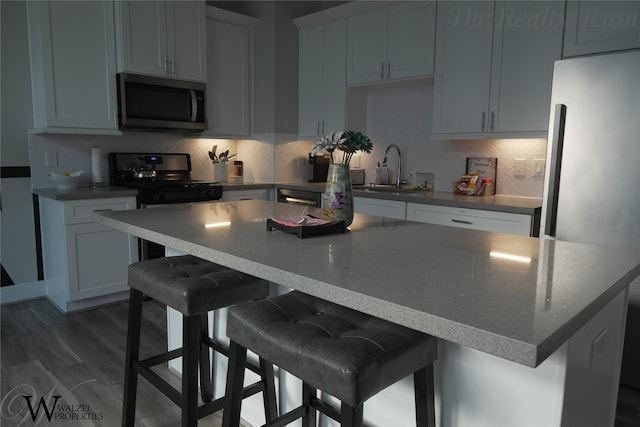 5902 Gardendale Dr Unit C, Houston, TX 77092 - kitchen with stainless steel appliances, a center island, tasteful backsplash, a breakfast bar, and dark wood finished floors