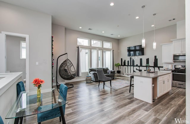 5902 Gardendale Dr Unit C, Houston, TX 77092 - kitchen with appliances with stainless steel finishes, a breakfast bar area, open floor plan, wood finished floors, and recessed lighting