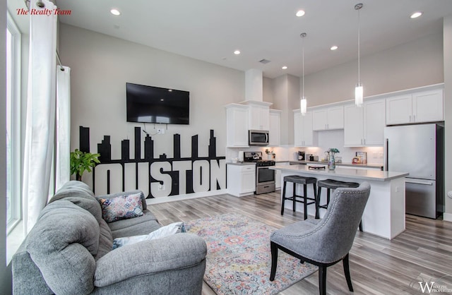 5902 Gardendale Dr Unit C, Houston, TX 77092 - living room with light wood-style flooring, a high ceiling, and recessed lighting
