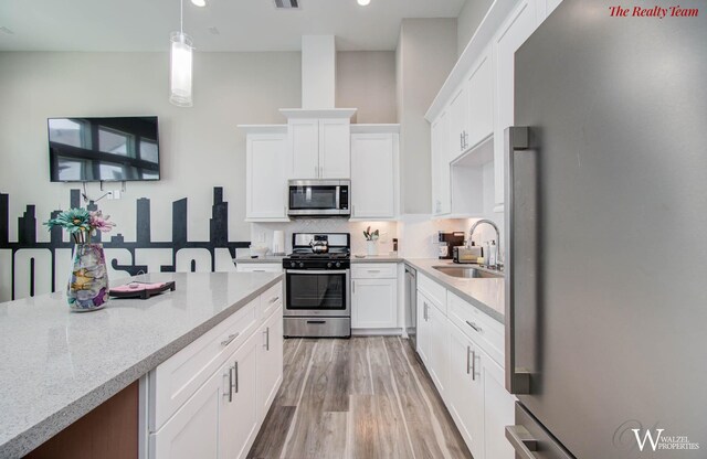 5902 Gardendale Dr Unit C, Houston, TX 77092 - kitchen featuring stainless steel appliances, tasteful backsplash, pendant lighting, light stone countertops, and white cabinetry