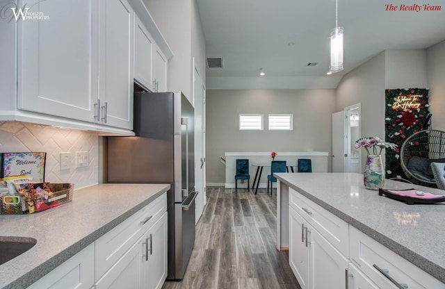 5902 Gardendale Dr Unit C, Houston, TX 77092 - kitchen with freestanding refrigerator, white cabinetry, backsplash, wood finished floors, and recessed lighting
