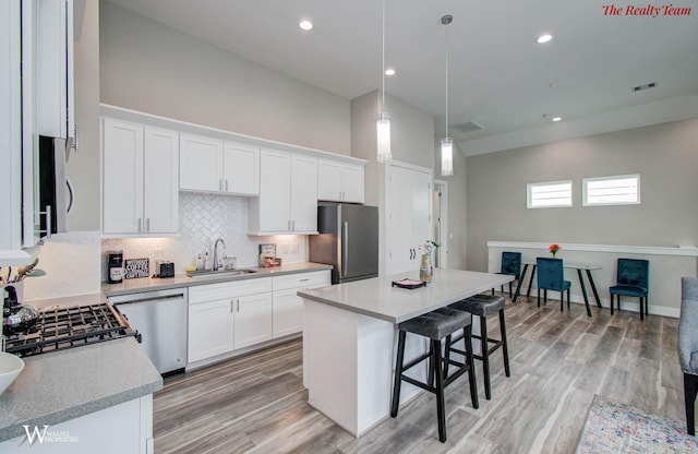 5902 Gardendale Dr Unit C, Houston, TX 77092 - kitchen with stainless steel appliances, a kitchen bar, backsplash, light countertops, and white cabinets
