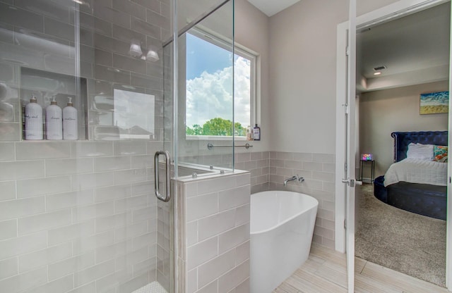 5902 Gardendale Dr Unit C, Houston, TX 77092 - ensuite bathroom featuring a freestanding bath, a stall shower, and tile walls