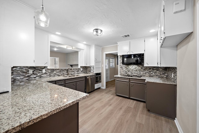 1033 25th Ave N, Texas City, TX 77590 - kitchen with black appliances, decorative backsplash, light wood-type flooring, white cabinets, and recessed lighting