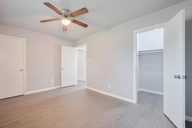 3602 Castledale Dr, Houston, TX 77093 - unfurnished bedroom with light wood-style floors, a walk in closet, and a ceiling fan
