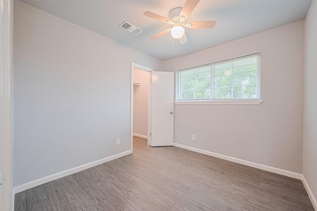 3602 Castledale Dr, Houston, TX 77093 - unfurnished bedroom with wood finished floors, a walk in closet, a closet, and ceiling fan