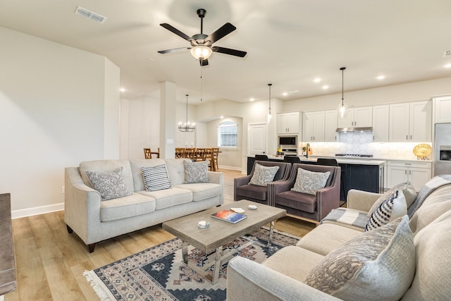 9806 Starry Night Ln, Manvel, TX 77578 - living room featuring light wood-style flooring, ceiling fan, recessed lighting, and a chandelier