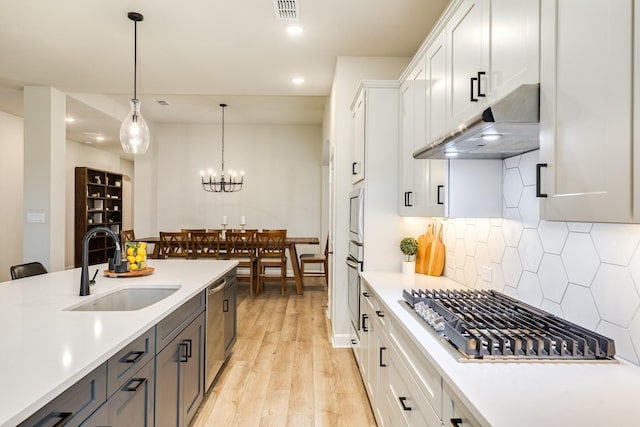 9806 Starry Night Ln, Manvel, TX 77578 - kitchen featuring under cabinet range hood, appliances with stainless steel finishes, light countertops, white cabinets, and recessed lighting