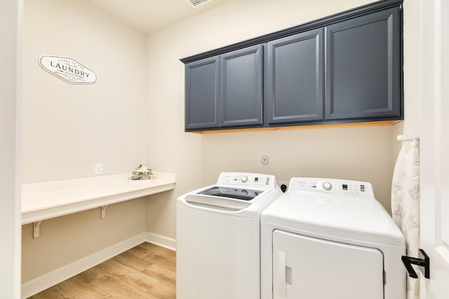 9806 Starry Night Ln, Manvel, TX 77578 - laundry area featuring cabinet space, independent washer and dryer, and light wood-style flooring