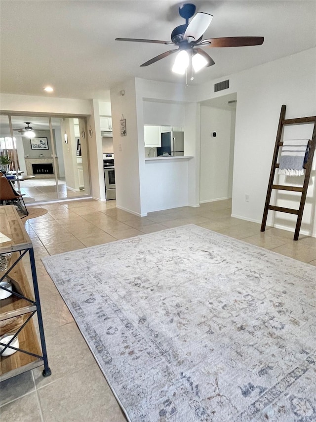 3300 Pebblebrook Dr Unit 17, Seabrook, TX 77586 - living area featuring a ceiling fan, light tile patterned floors, and a fireplace