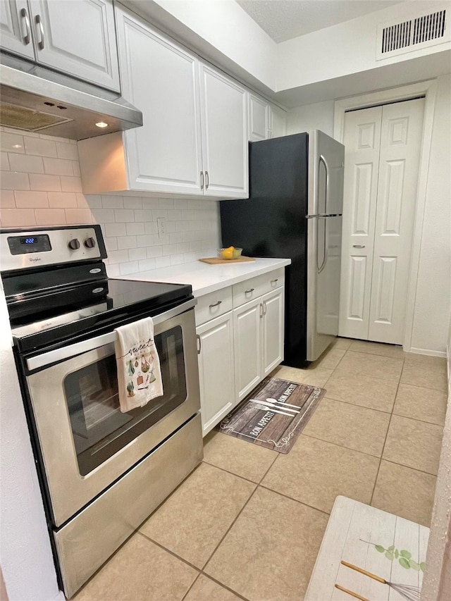 3300 Pebblebrook Dr Unit 17, Seabrook, TX 77586 - kitchen with stainless steel appliances, extractor fan, white cabinets, light countertops, and backsplash