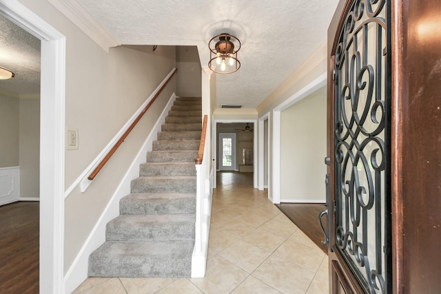346 Ballantrae Ln, Houston, TX 77015 - foyer entrance featuring a textured ceiling, stairway, light tile patterned floors, and crown molding