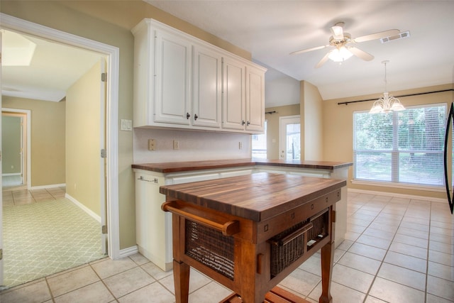 2115 Greentree Dr, Huntsville, TX 77340 - kitchen with wooden counters, ceiling fan, light tile patterned floors, white cabinets, and vaulted ceiling