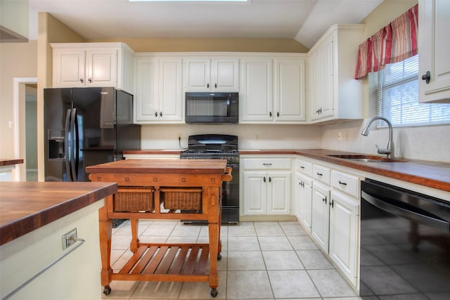2115 Greentree Dr, Huntsville, TX 77340 - kitchen featuring black appliances, white cabinetry, butcher block countertops, and light tile patterned flooring