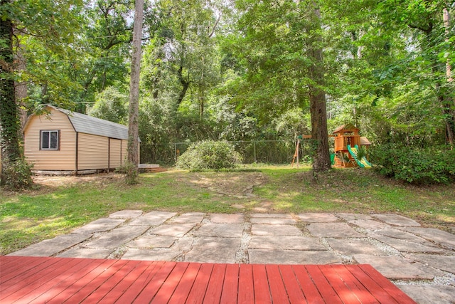 2115 Greentree Dr, Huntsville, TX 77340 - deck with a playground, a shed, a fenced backyard, and a patio area