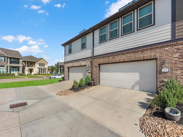 9440 Caddo Ridge Ln, Cypress, TX 77433 - view of front facade with an attached garage, brick siding, concrete driveway, and a residential view