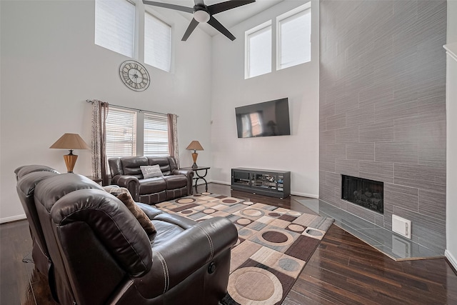 14212 Rocky Briar Ln, Rosharon, TX 77583 - living area with a ceiling fan, a towering ceiling, wood finished floors, and a tiled fireplace