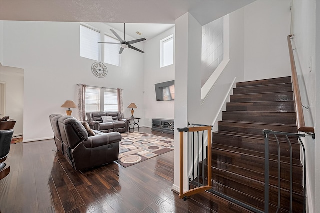 14212 Rocky Briar Ln, Rosharon, TX 77583 - living area with ceiling fan, plenty of natural light, wood finished floors, stairs, and a towering ceiling