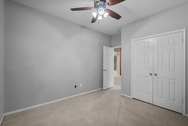 110 Crimson Bay Dr, League City, TX 77573 - unfurnished bedroom with light colored carpet, a closet, and a ceiling fan