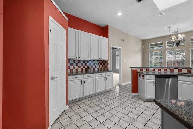 110 Crimson Bay Dr, League City, TX 77573 - kitchen with tasteful backsplash, a chandelier, a textured ceiling, white cabinetry, and a skylight
