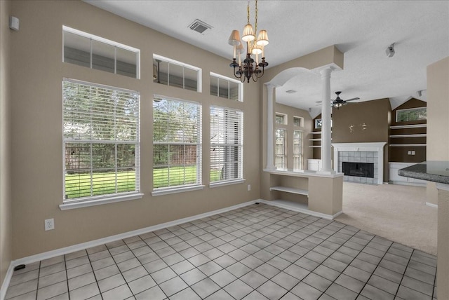 110 Crimson Bay Dr, League City, TX 77573 - unfurnished dining area with plenty of natural light, a textured ceiling, ceiling fan, a fireplace, and light tile patterned floors