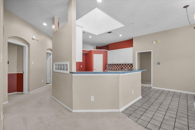 110 Crimson Bay Dr, League City, TX 77573 - kitchen with white cabinets, tasteful backsplash, arched walkways, dark countertops, and recessed lighting