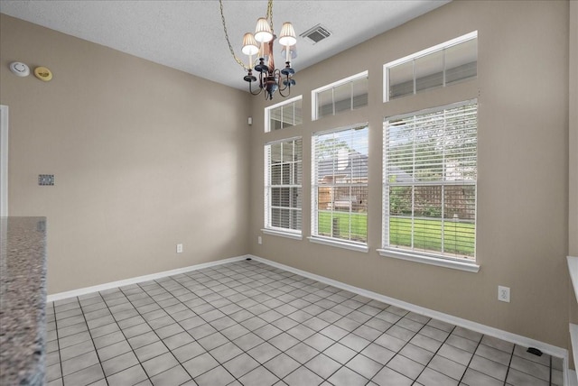 110 Crimson Bay Dr, League City, TX 77573 - unfurnished dining area featuring a chandelier, a textured ceiling, and tile patterned floors