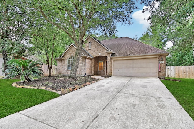 55 Bowie Bend Ct, The Woodlands, TX 77385 - view of front of home featuring a garage, driveway, brick siding, and a shingled roof