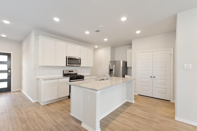 5827 Fresh View Ct, Katy, TX 77493 - kitchen featuring appliances with stainless steel finishes, light wood finished floors, a kitchen island with sink, white cabinetry, and recessed lighting