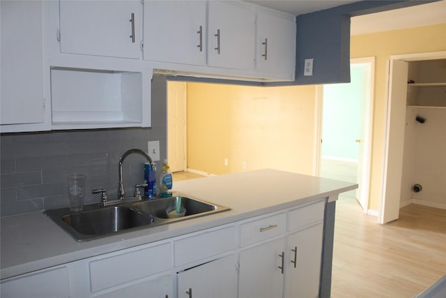 6161 Reims Rd Unit 611, Houston, TX 77036 - kitchen with tasteful backsplash, light wood-style floors, white cabinetry, and light countertops