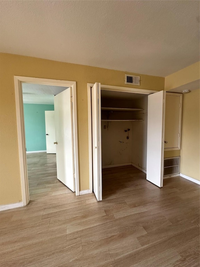 6161 Reims Rd Unit 611, Houston, TX 77036 - hall with light wood-style flooring and a textured ceiling