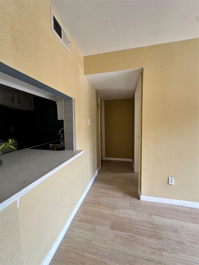 6161 Reims Rd Unit 611, Houston, TX 77036 - hallway with a textured ceiling, wood finished floors, and a textured wall