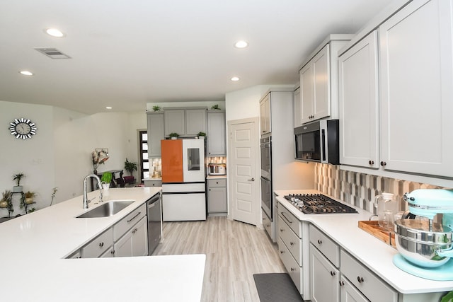 3819 Ethan Park Ct, Katy, TX 77494 - kitchen featuring appliances with stainless steel finishes, recessed lighting, light wood finished floors, light countertops, and gray cabinetry