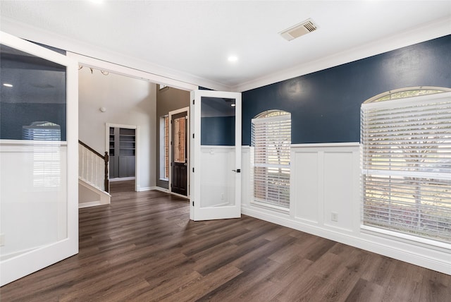 12014 Via Davinci Ln NW, Cypress, TX 77429 - unfurnished room with ornamental molding, dark wood-style floors, a decorative wall, wainscoting, and stairway