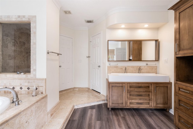 12014 Via Davinci Ln NW, Cypress, TX 77429 - bathroom featuring ornamental molding, vanity, a garden tub, wood finished floors, and decorative backsplash