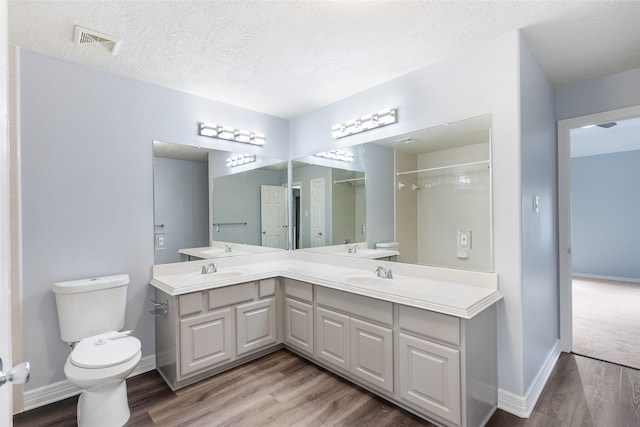 12014 Via Davinci Ln NW, Cypress, TX 77429 - full bath featuring wood finished floors, double vanity, a textured ceiling, and a shower