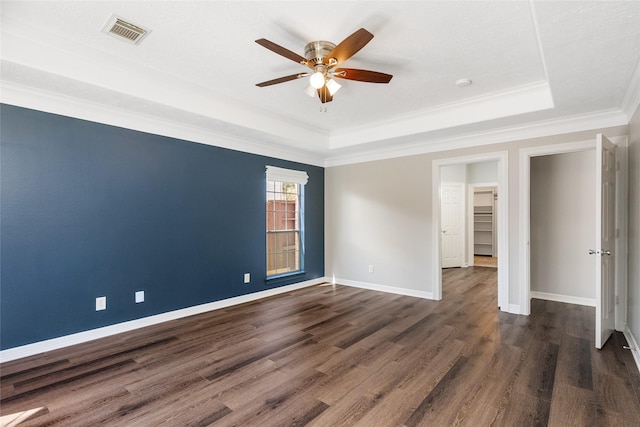 12014 Via Davinci Ln NW, Cypress, TX 77429 - spare room with a tray ceiling, a ceiling fan, dark wood-style flooring, and ornamental molding