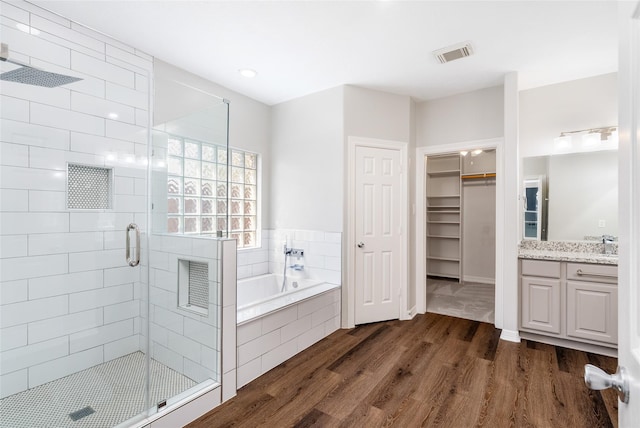 12014 Via Davinci Ln NW, Cypress, TX 77429 - bathroom featuring wood finished floors, vanity, a shower stall, a bath, and a walk in closet