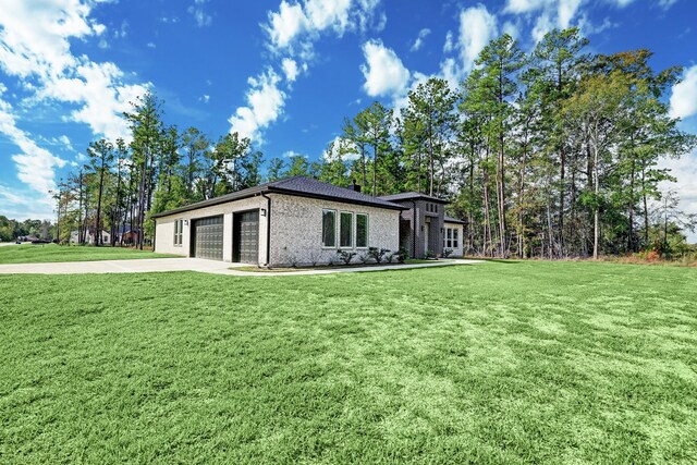 13 Rd 66111, Dayton, TX 77535 - view of side of home with driveway, an attached garage, a lawn, and brick siding