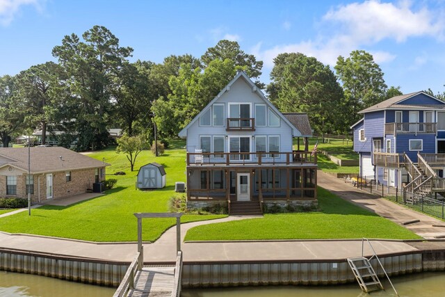 426 Apollo Dr, Livingston, TX 77351 - rear view of property with a lawn, a balcony, a deck with water view, and a storage unit