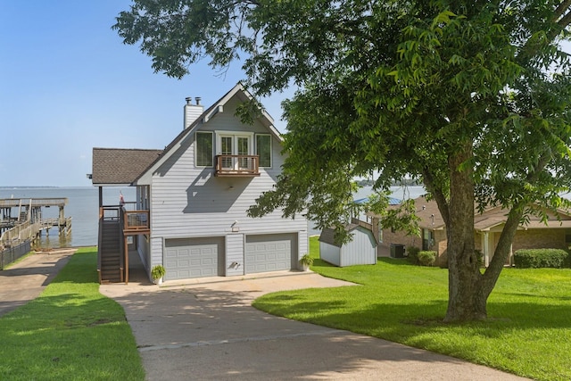 426 Apollo Dr, Livingston, TX 77351 - view of front of property featuring concrete driveway, stairway, a garage, a front yard, and a chimney