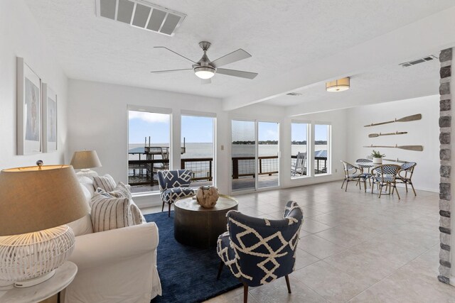 426 Apollo Dr, Livingston, TX 77351 - living area with a ceiling fan, light tile patterned floors, and a water view