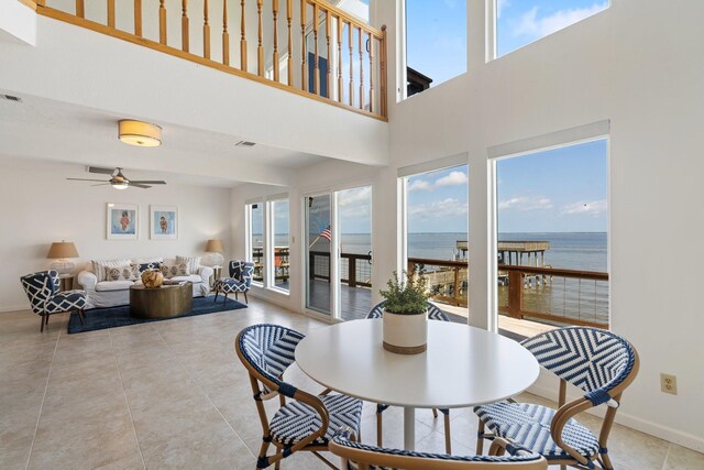 426 Apollo Dr, Livingston, TX 77351 - dining area featuring a water view, ceiling fan, a towering ceiling, and light tile patterned floors