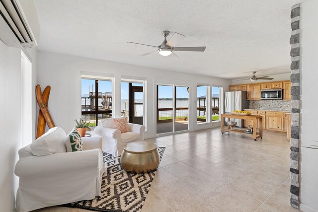 426 Apollo Dr, Livingston, TX 77351 - living room with a wall mounted air conditioner, a ceiling fan, light tile patterned flooring, a textured ceiling, and a water view