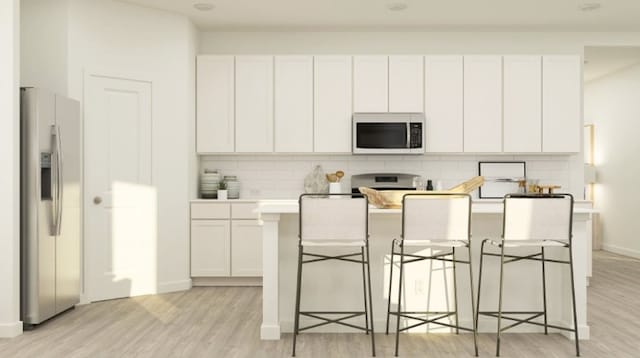 1203 Garrett Sudhendrio Dr, Crosby, TX 77532 - kitchen featuring appliances with stainless steel finishes, tasteful backsplash, light wood finished floors, and white cabinets