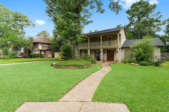 27277 Wells Ln, Conroe, TX 77385 - view of front facade with a front yard, brick siding, and a balcony