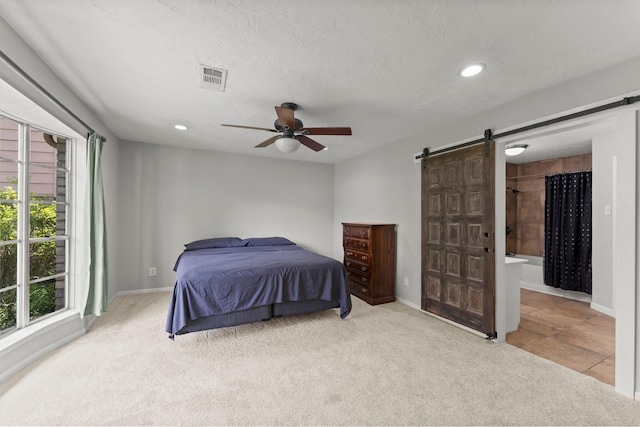 27277 Wells Ln, Conroe, TX 77385 - bedroom featuring a barn door, light carpet, recessed lighting, ceiling fan, and a textured ceiling