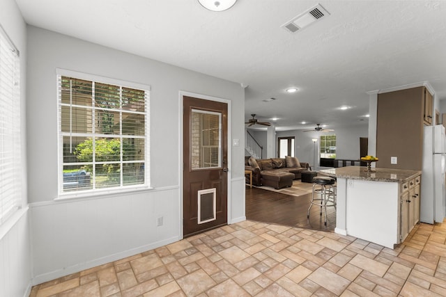 27277 Wells Ln, Conroe, TX 77385 - kitchen with freestanding refrigerator, brick patterned flooring, a ceiling fan, open floor plan, and a kitchen breakfast bar