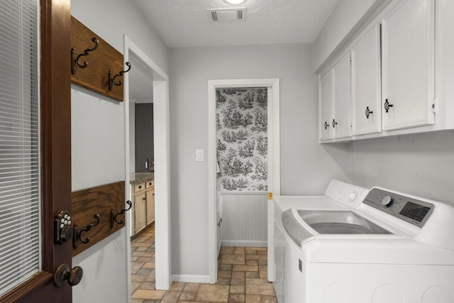 27277 Wells Ln, Conroe, TX 77385 - washroom featuring independent washer and dryer, light stone finish floors, cabinet space, and a wainscoted wall